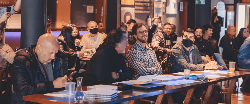 Publico reunido em mesas num evento do FABLAB HUB
